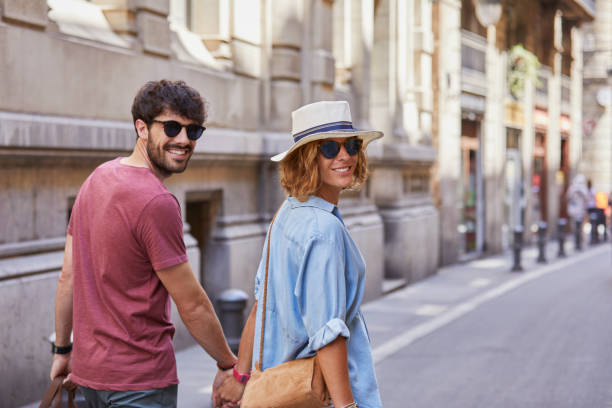 Couple de voyageurs qui porte des lunettes de soleil, un chapeau et un sac à bandoulière